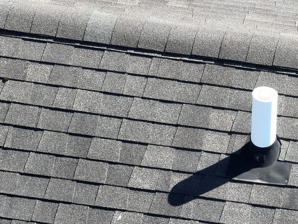 Plumbing vent pipe and its rubber boot on a shingle roof