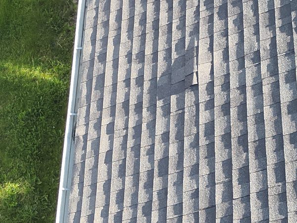 Asphalt shingle roof with a darker patch of shingles that doesn't match