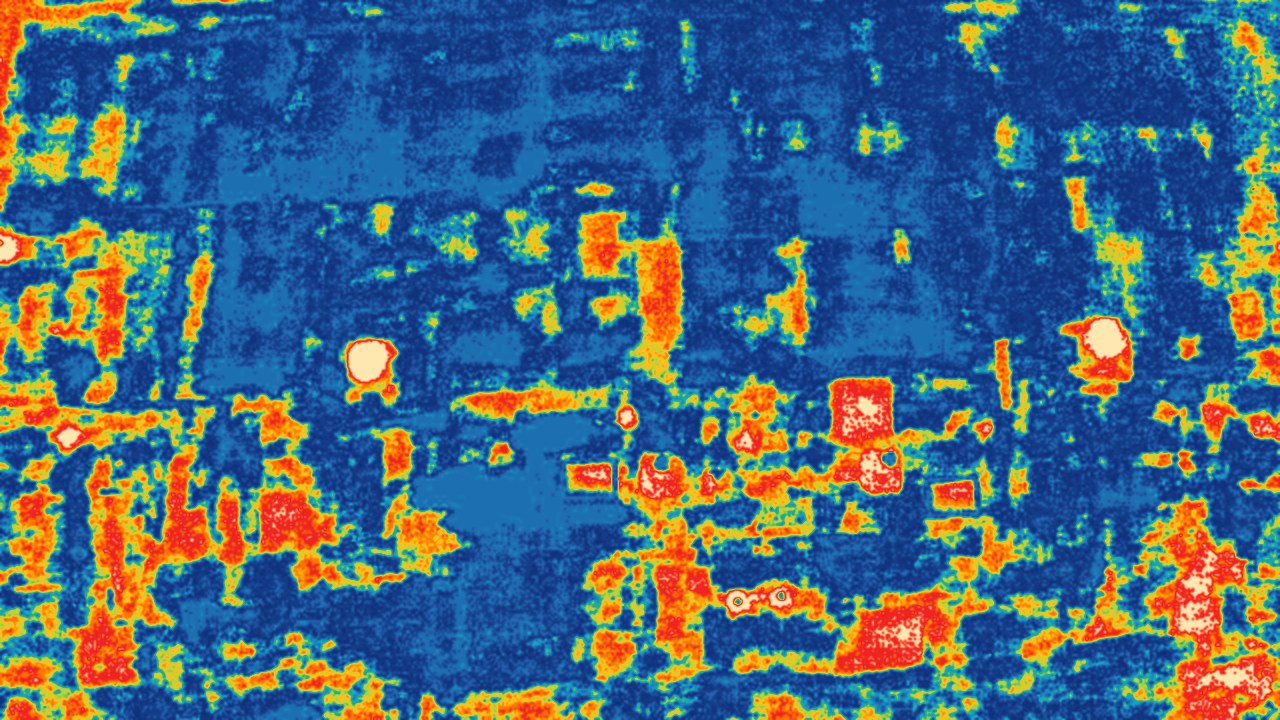 Thermal image of the same flat roof: cooler areas in blue and green, warmer areas in yellow, orange and red